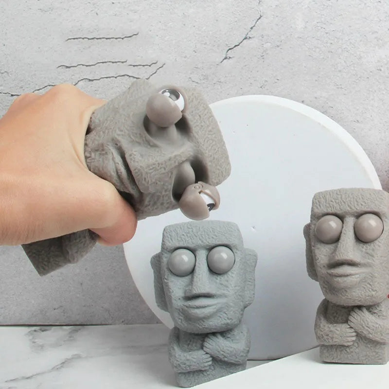 Stone man releases stress toy slowly rebounds soft Moai statue squeeze